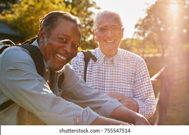 Portrait Of Two Male Senior Friends Hiking In Countryside