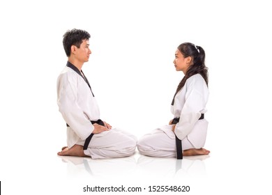 Portrait of two martial art practitioners sitting on their knees, facing each others. Full length, side view, studio shot - Powered by Shutterstock