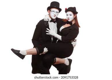 Portrait of two mime artists performing, isolated on white background. Woman is sitting on the mans knee. Symbol of close friendship, relations, trust relationship