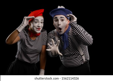 Portrait of two mime sailors looking into distance on black. Amusing pantomime performance by talented artists.