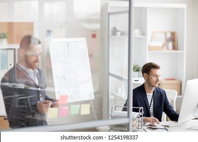Portrait Of Two Modern People Working In Office In Cubicles Separated By Glass Walls, Cop Space