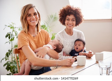 Portrait Of Two Mothers With Babies Meeting Around Table On Play Date At Home