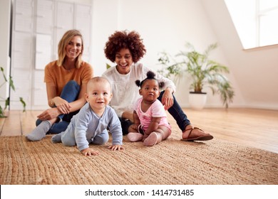 Portrait Of Two Mothers Meeting For Play Date With Babies At Home In Loft Apartment