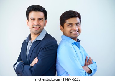 Portrait of two multiethnic businessmen standing back to back with their arms crossed and smiling at camera over white background - Shutterstock ID 1349775155