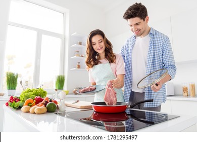 Portrait Of Two Nice Attractive Cheerful Friendly People Cooking Domestic Fresh Homemade Meal In Light White Interior Kitchen House Apartment Indoors