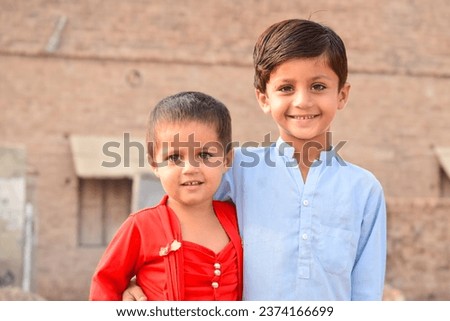 Portrait of two Pakistani Brother and sister posing against blurred background and playing in house yard. Pakistani kids. Pakistani babies playing. Asian kid. Stylish Asia kids. Punjab Pakistan.