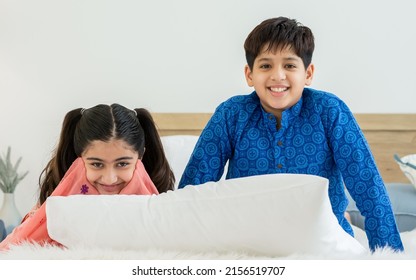 Portrait two people, Indian teenage brother, sister wearing traditional clothes, smiling with happiness and fun, looking at camera on bed at cozy home. Family, Education, Lifestyle Concept - Shutterstock ID 2156519707
