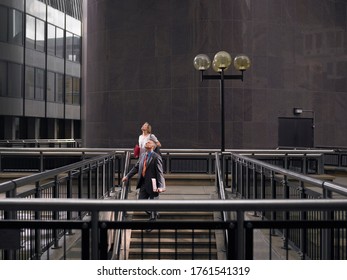 Portrait Of Two People Walking Down Stairs While Looking Up