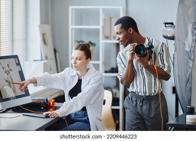 Portrait Of Two Photographers Working As Team On Product Photoshoot In Studio