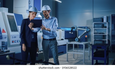 Portrait of Two Professional Engineers Use Industrial Digital Tablet to Work with Augmented Reality. Great Template Shot for Augmented Reality. Factory Workshop with CNC Machinery.