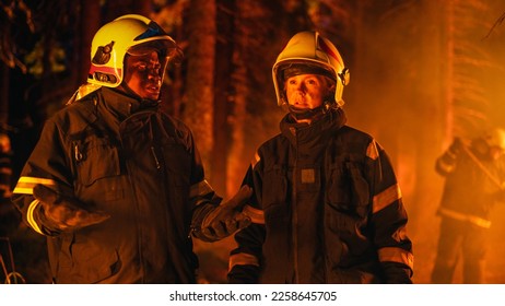 Portrait of Two Professional Firefighters Standing in a Forest, Discussing the Situation Report During a Wildland Fire. Focused Female Superintendent Talking with African American Squad Leader. - Shutterstock ID 2258645705