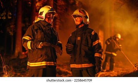 Portrait of Two Professional Firefighters Standing in a Forest, Discussing the Situation Report During a Wildland Fire: Female Superintendent Talking with African American Squad Leader. - Shutterstock ID 2258645709