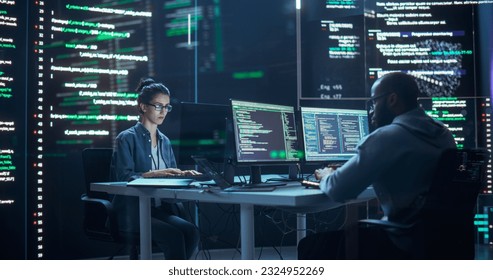 Portrait of Two Programmers Working in a Monitoring Control Room, Surrounded by Big Screens Displaying Lines of Programming Language Code. Portrait of Diverse Developers Creating a Software, Coding - Powered by Shutterstock