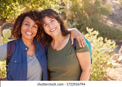 Portrait Of Two Senior Female Friends Hiking Along Trail In Countryside Together