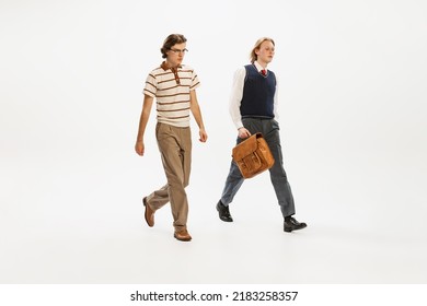 Portrait of two seriously looking man in retro style outfit walking isolated over white studio background. Business people. Concept of retro fashion, style, youth culture, emotions, beauty, ad - Powered by Shutterstock