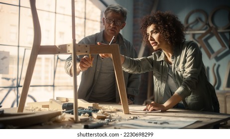 Portrait of Two Small Business Owners Working Together on Creating a New Wooden Dining Table Chair Design. Adult Man and Young Beautiful Female Looking at a Blueprint and Discussing the Work Process. - Powered by Shutterstock