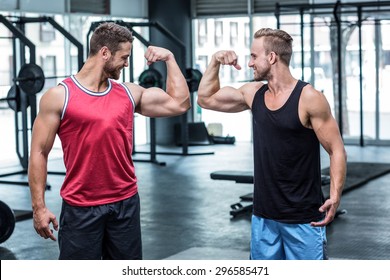 Portrait of two smiling muscular men flexing biceps - Powered by Shutterstock