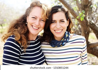 Portrait of two smiling real mature women outdoor