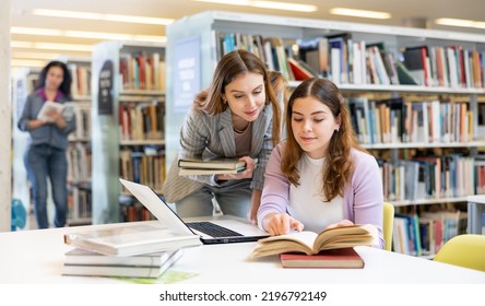 Portrait of two smiling woman working in university library - Powered by Shutterstock