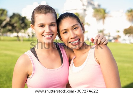 Portrait of two smiling women wearing pink for breast cancer in parkland