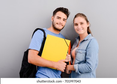 Portrait Of Two Student Male And Female On Grey Plain Background With Copyspace