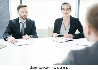 Portrait Of Two Successful Business People, Man And Woman,  Talking To Partner Sitting Across Meeting Table And Negotiating  In Conference Room, Copy Space