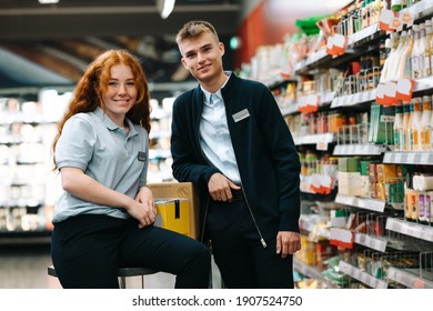 Portrait Of A Two Supermarket Workers. Boy And Girl On Holiday Job At Local Grocery Store.