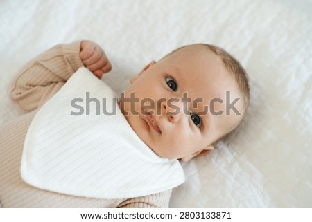 Portrait of a two to three month old baby with visible drool on lips. Natural process of infant development associated with increased saliva production in early infancy.