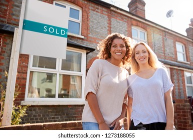 Portrait Of Two Women Standing Outside New Home With Sold Sign - Powered by Shutterstock