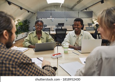 Portrait Of Two Young African-American People Smiling At Business Partners Sitting Across Table During Meeting In Modern Office, Copy Space