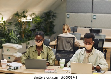 Portrait Of Two Young African-American People Wearing Masks While Working At Desk In Post Pandemic Office, Copy Space