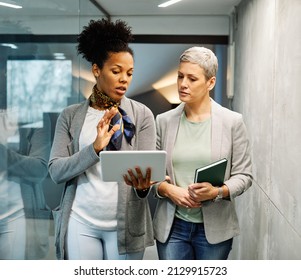 Portrait of two young business woman having a meeting or presentation and seminar standing in the office. Portrait of a young business woman talking - Powered by Shutterstock