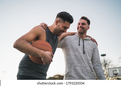 Portrait of two young friends playing basketball and having fun on court outdoors. Sport concept. - Powered by Shutterstock