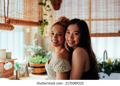 A Portrait Of Two Young Multi Racial Same Sex Couple Hugging At Home And Smiling At The Camera