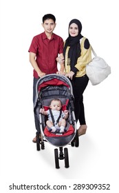 Portrait Of Two Young Muslim Parents With Male Baby On The Pram, Isolated On White