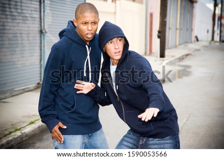 Portrait of two young street gang members looking suspicious
