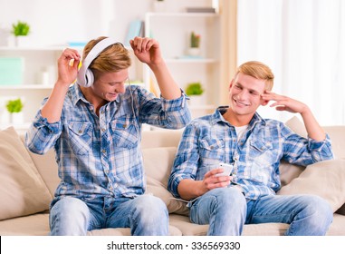 Portrait of two young twin boys having fun sitting on the couch at home
