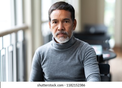 Portrait Of Unhappy Angry Mature Asian Man With Stylish Short Beard Looking At Cemera With Negative Suspicious. Casual Retired Hispanic People Feeling Worry Or Unpleasant At Outside Cafe Concept.