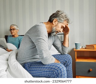 Portrait of unhappy senior couple during or after arguing while sitting on bed, married elderly couple discussing in bed - Powered by Shutterstock