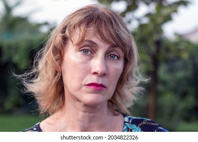 Portrait Of An Unhappy Woman Of Middle Age 50-55 Years Old With Blond Hair, Sad Eyes