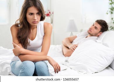 Portrait Of Unhappy Young Heterosexual Couple In Bedroom