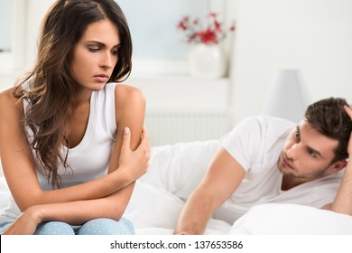 Portrait Of Unhappy Young Heterosexual Couple In Bedroom