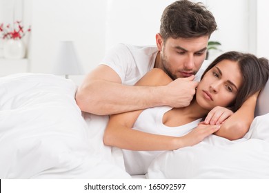 Portrait Of Unhappy Young Heterosexual Couple In Bedroom