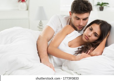 Portrait Of Unhappy Young Heterosexual Couple In Bedroom