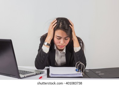 Portrait of unhappy young woman with computer and documents indoors

