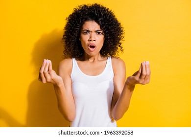 Portrait of unsatisfied dark skin lady open mouth arms fingers show money symbol isolated on yellow color background