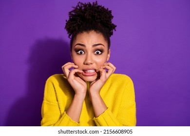 Portrait of unsatisfied frightened girl bite fingers stare speechless isolated on purple color background