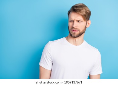 Portrait of unsatisfied man look interested empty space sullen eyebrows lips isolated on blue color background