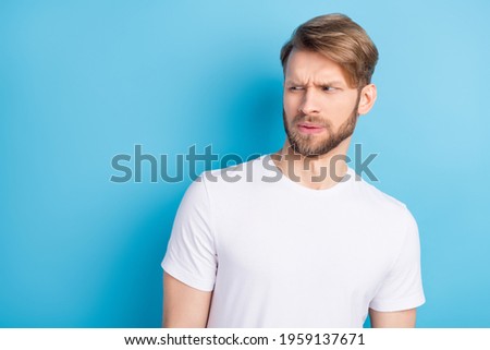 Portrait of unsatisfied man look interested empty space sullen eyebrows lips isolated on blue color background
