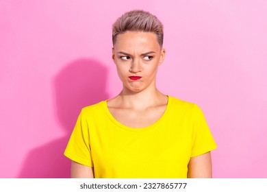 Portrait of unsatisfied offended angry pretty lady sullen face look empty space isolated on pink color background